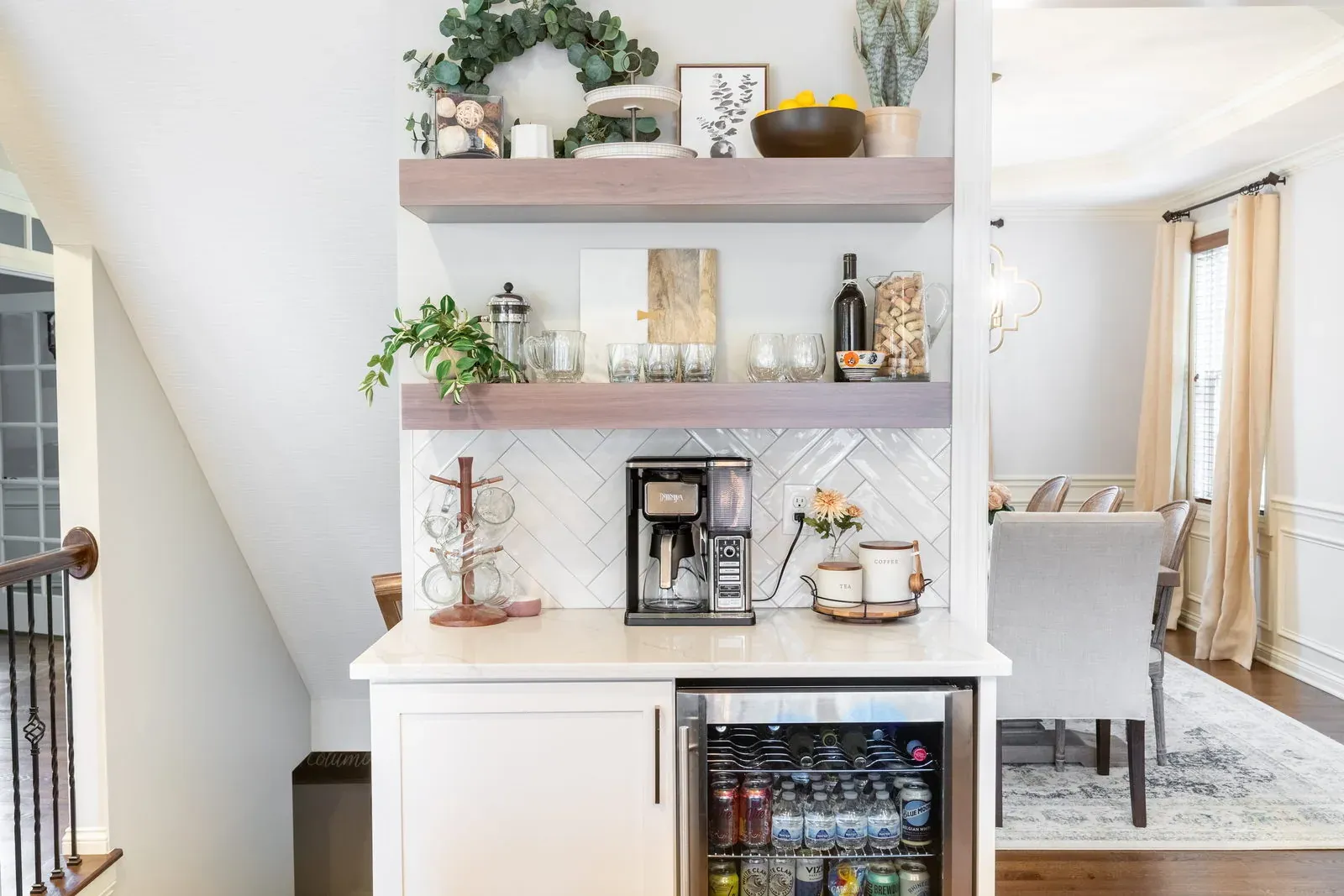 Built-in coffee bar with stained floating shelves, herringbone tile, quartz counter and an undercounter beverage refrigerator
