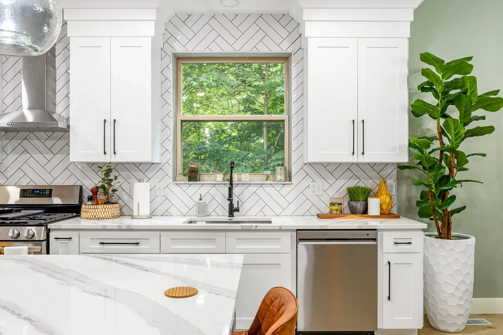 Kitchen sink wall with white herringbone tile to the ceiling, a matte black faucet, quartz countertops and a wood-trimmed window over the sink